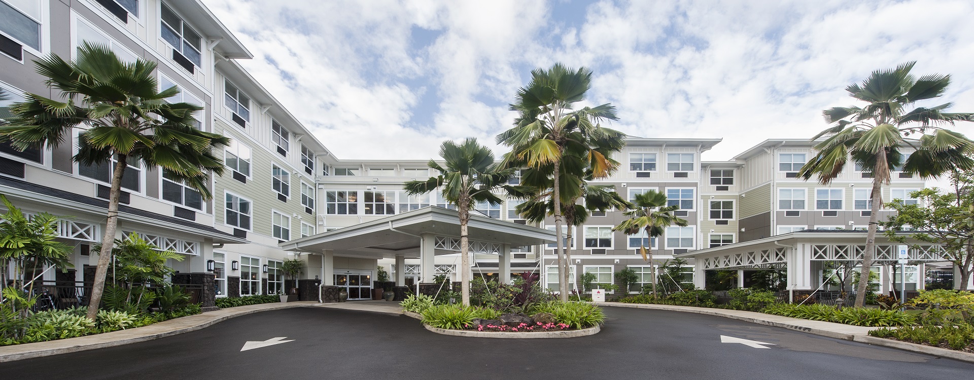 Palm-lined entryway and driveway of The Plaza Assisted Living Kaneohe.