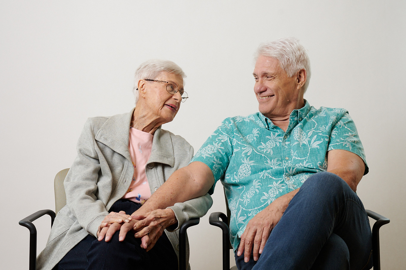 Family member holding a resident's hand at The Plaza Assisted Living.