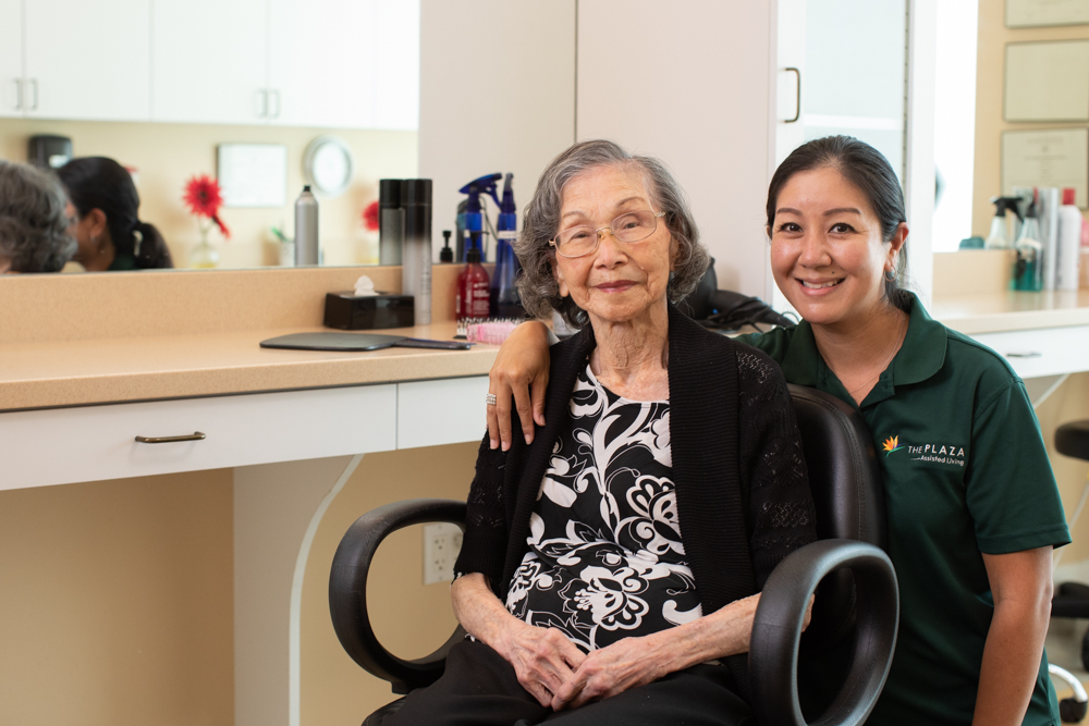 Staff member with a resident in the salon at The Plaza Assisted Living.