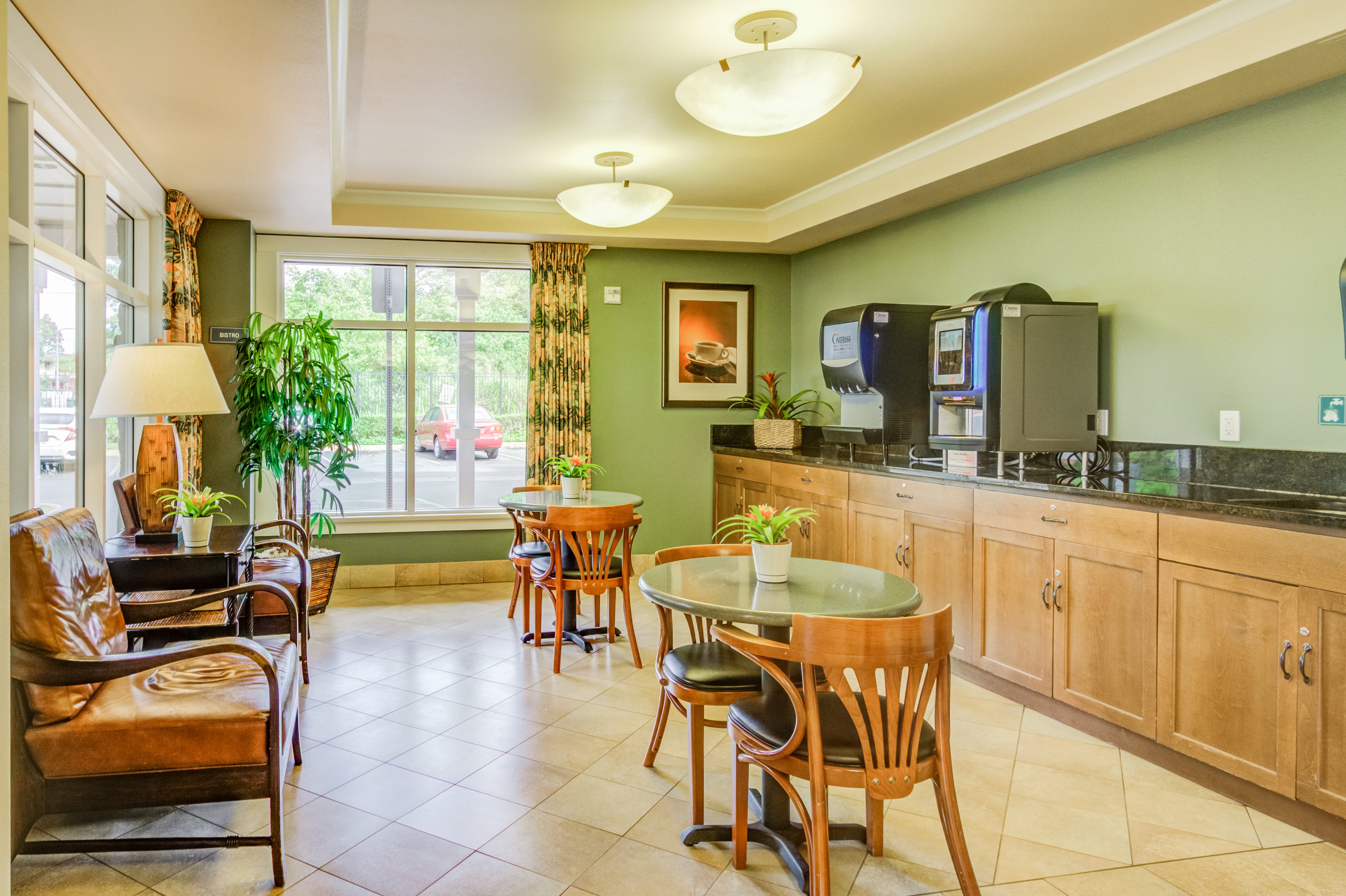 Indoor bistro area with coffee machines and seating at The Plaza Assisted Living.