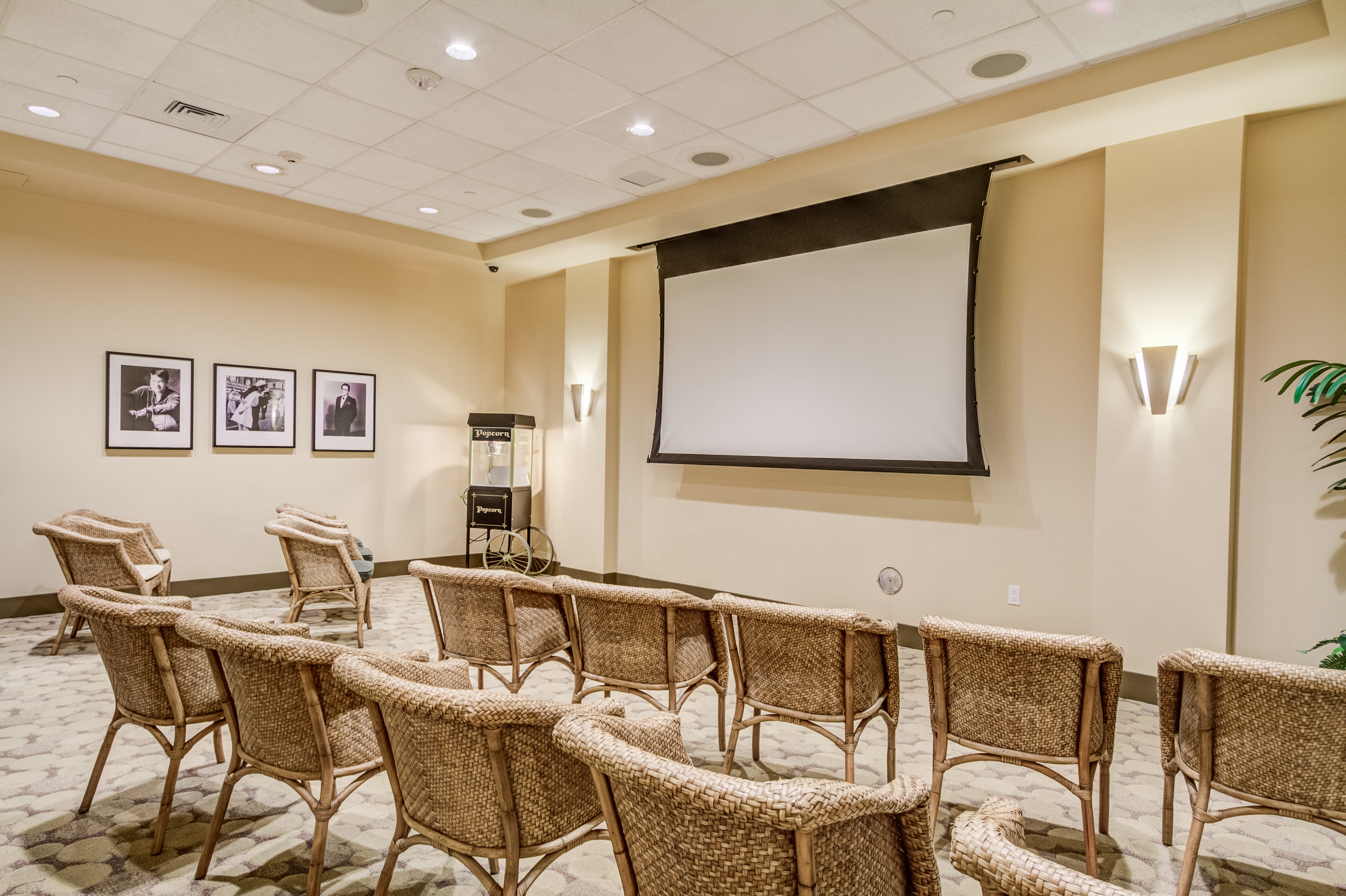 Resident media room at The Plaza Assisted Living with a large screen and popcorn machine.