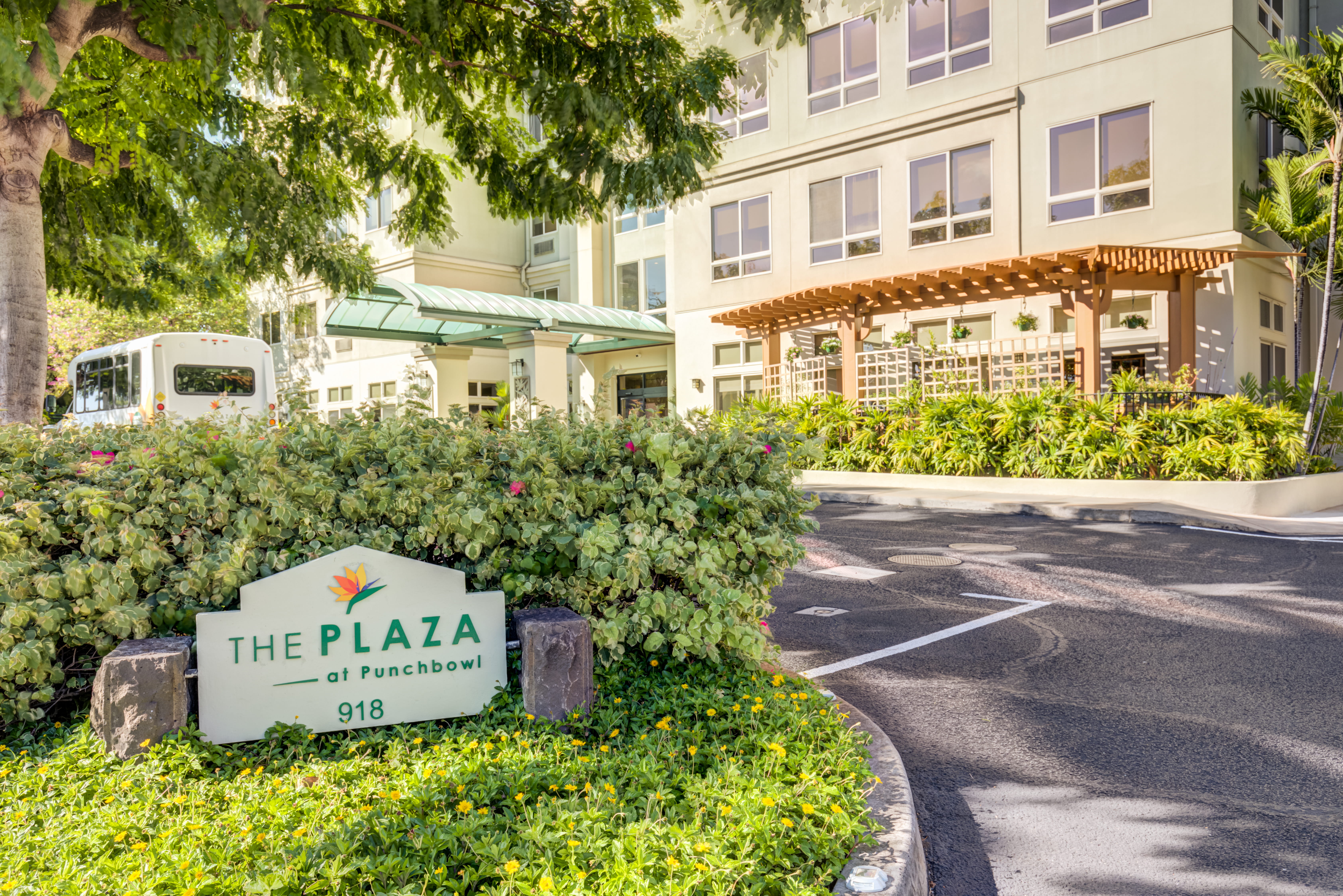 Entrance sign for The Plaza at Punchbowl surrounded by flowers.