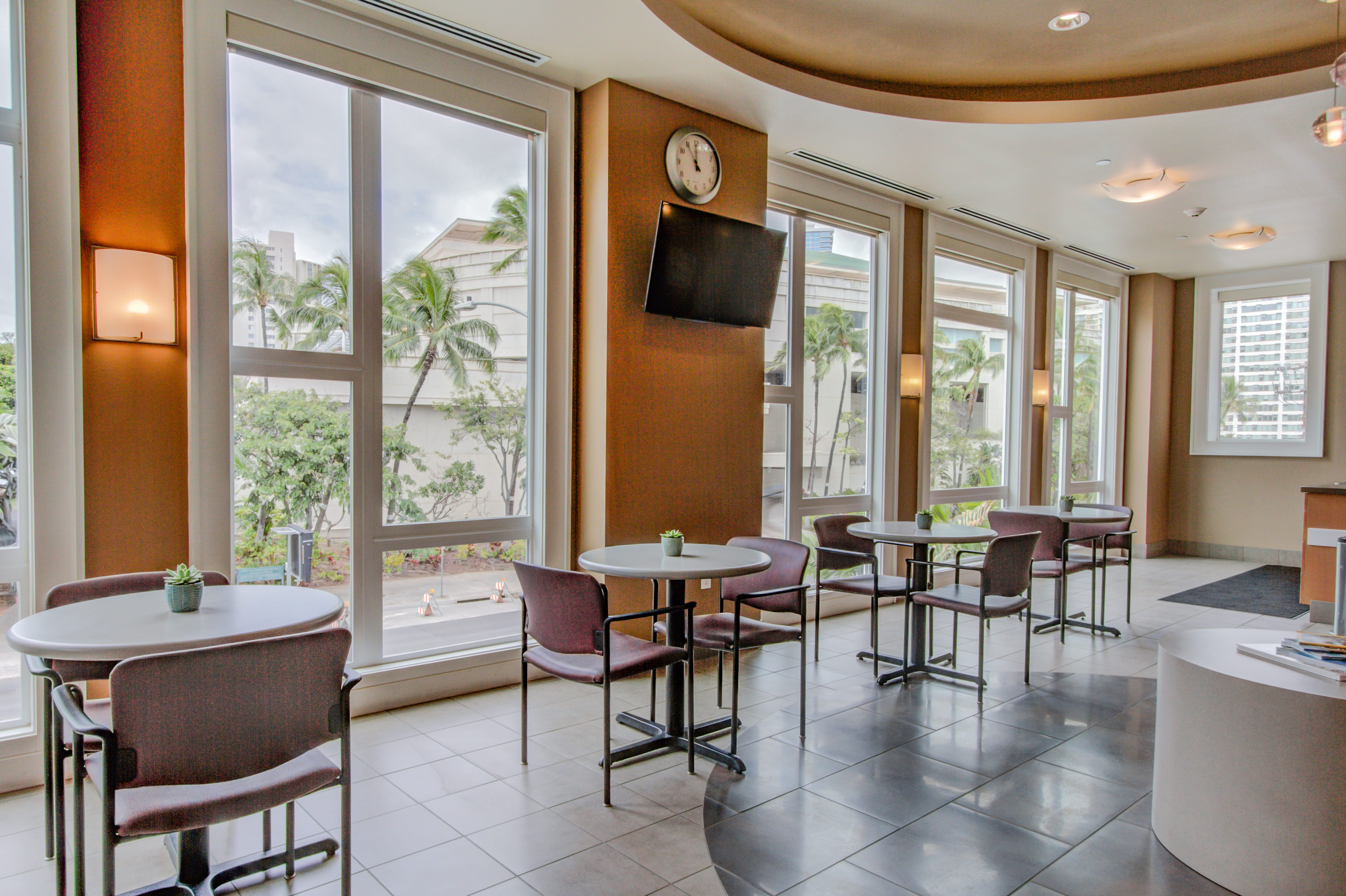 Sun-drenched bistro with palm tree views at The Plaza at Waikiki.