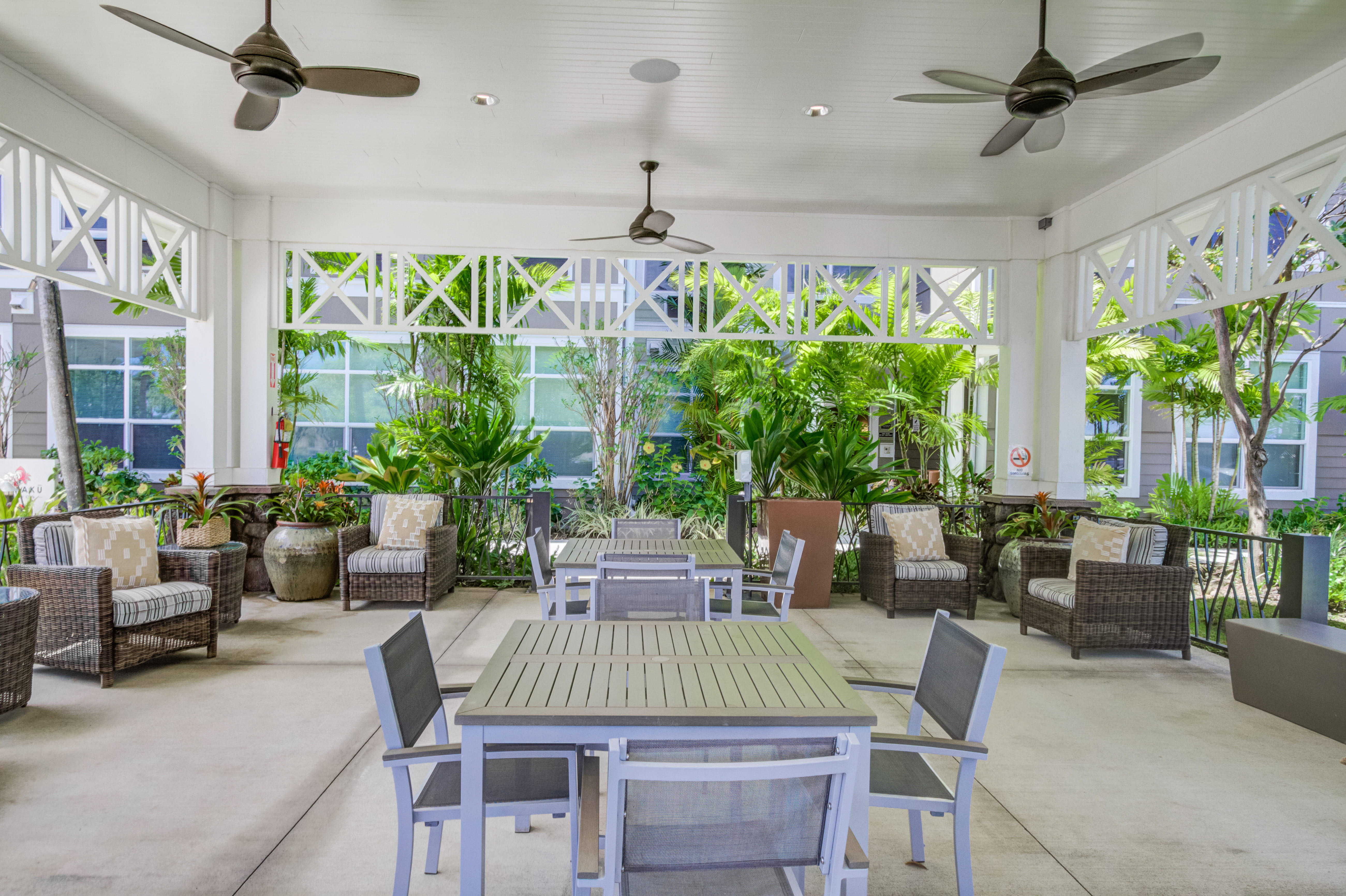 Covered outdoor patio with wicker furniture at The Plaza Assisted Living.