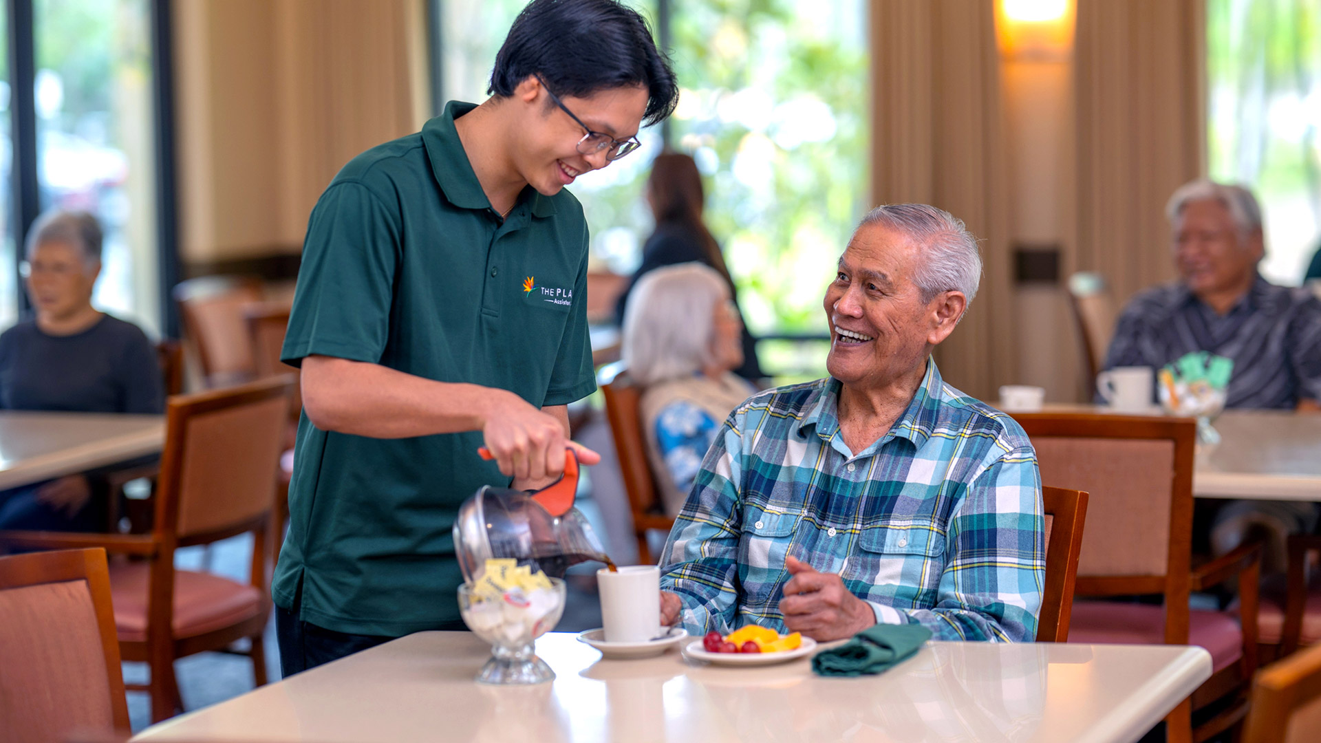 Staff member pouring coffee for a resident at The Plaza Assisted Living.