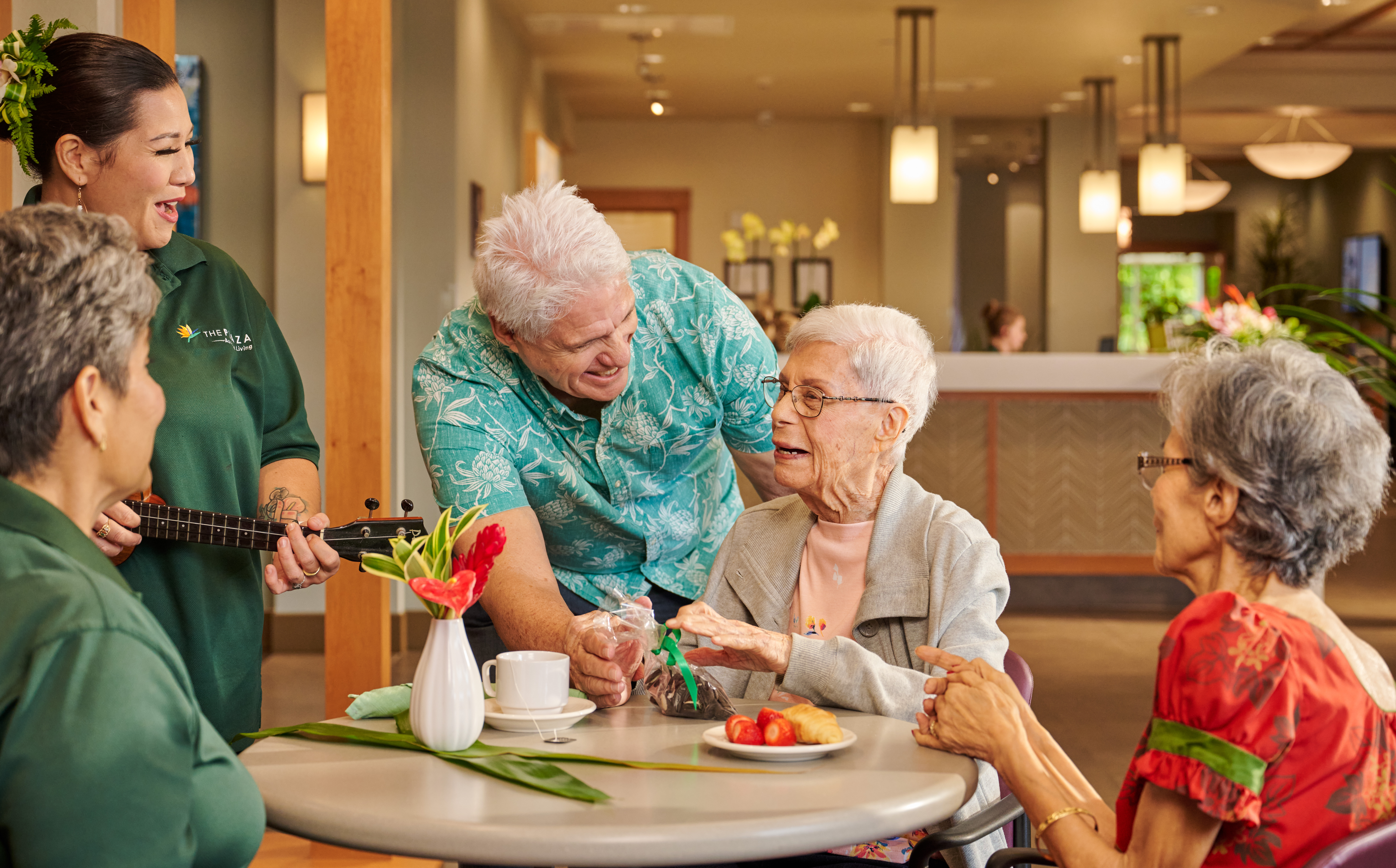Staff member playing ukulele for residents at The Plaza Assisted Living.